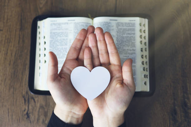 Hands female prayer to Load with broken heart in hands on the bible,Concept Pray for liberation,sin,no freedom.